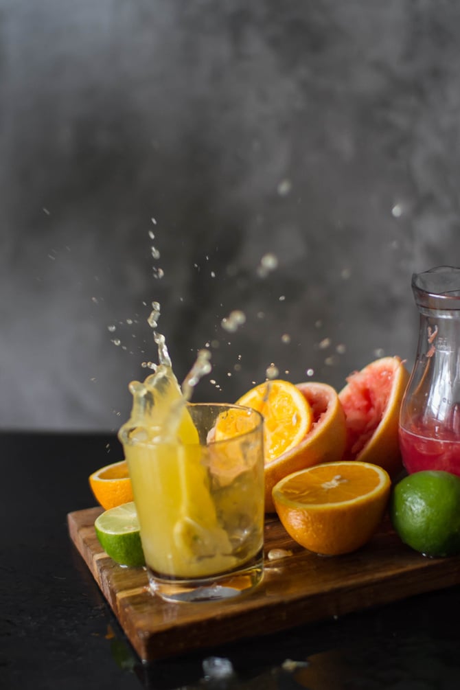 Fresh juice splashing near fruits